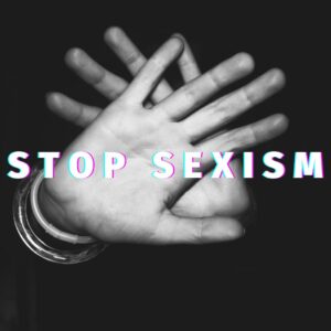Two hands with a gesture of stop and the message "stop sexism"